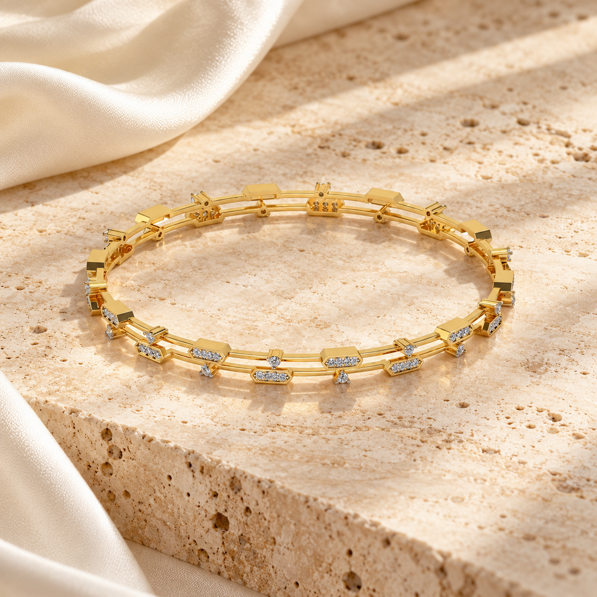 Hesperos Yellow Gold Silver Bangles arranged on warm neutral stone and ivory silk